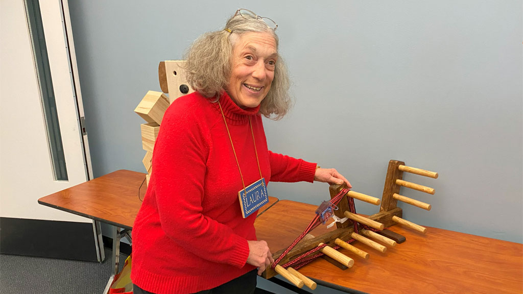 Laura Rhodes holds a custom-made Inkle loom.
